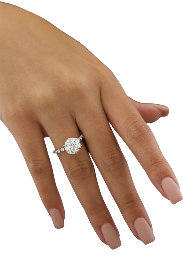 A solitaire diamond ring photographed on a hand, from the studio’s own pictures